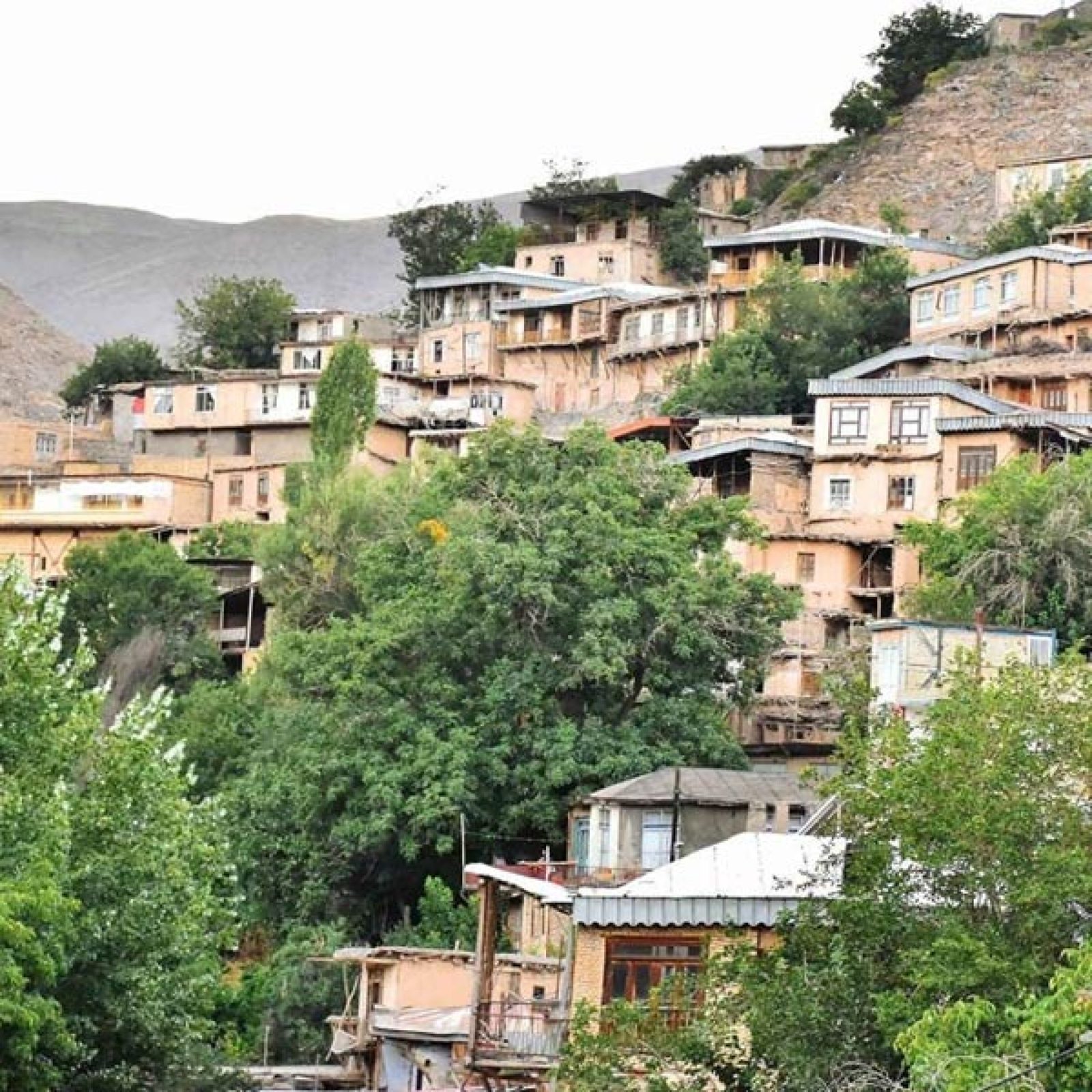 Terraced stone houses of Kang village on a green mountain slope near Mashhad
